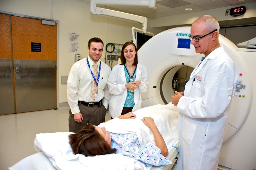 Radiologists and technologist explain nuclear medicine to a patient