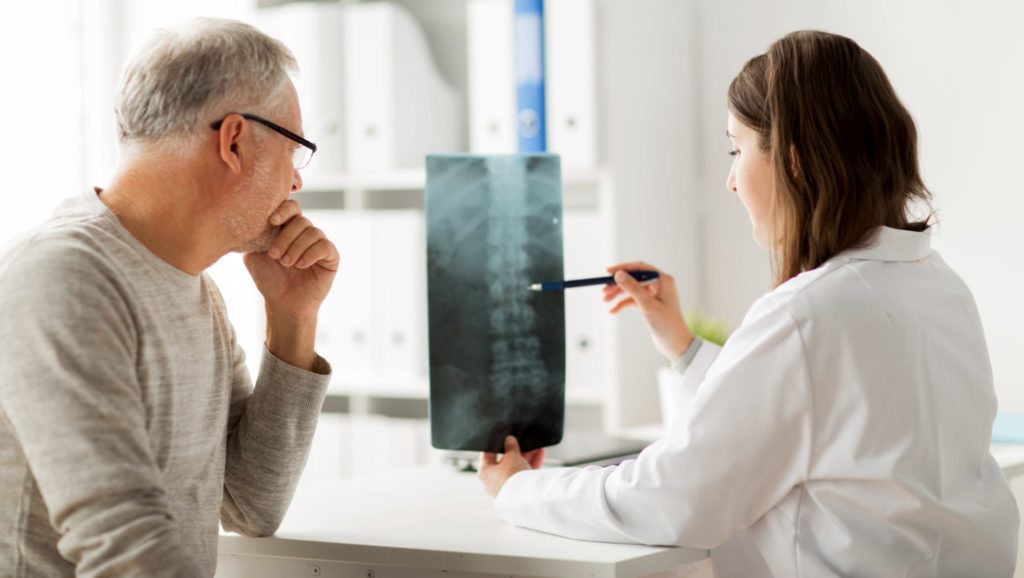 A patient and doctor look at an x-ray together