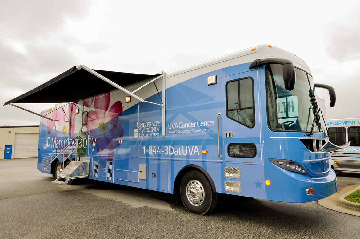 a charter bus that has been converted into a mammography screening center sits in a wet parking lot