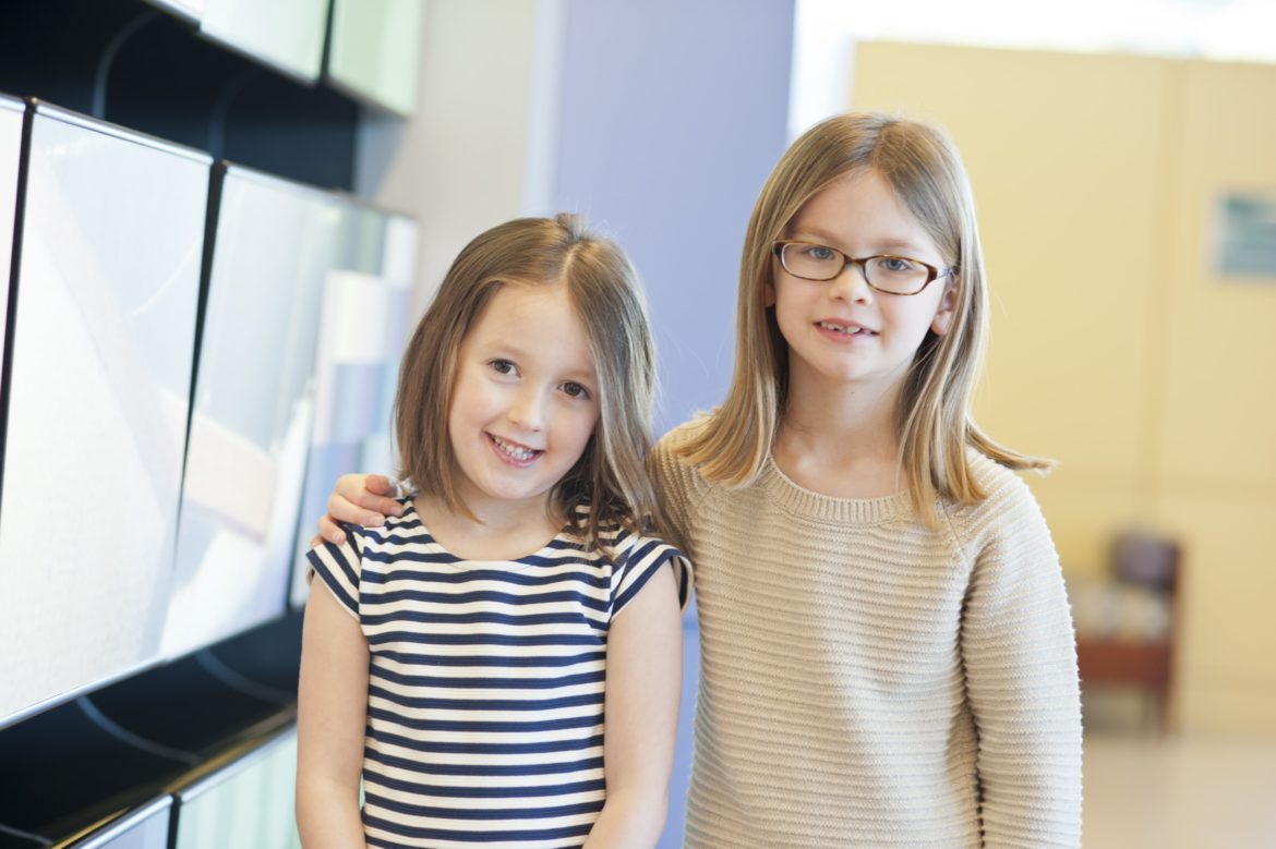 Two girls stand next to each other in the UVA pediatric radiology office