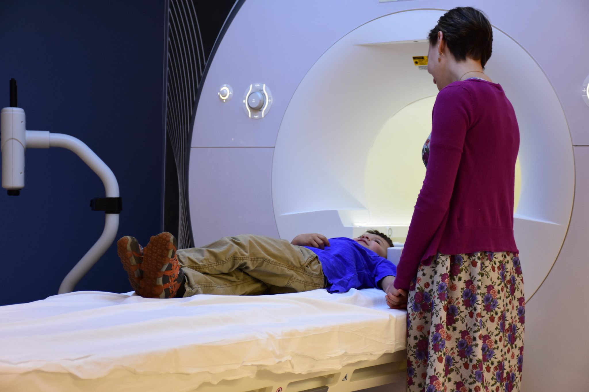 A child gets an MRI done as his mother watches