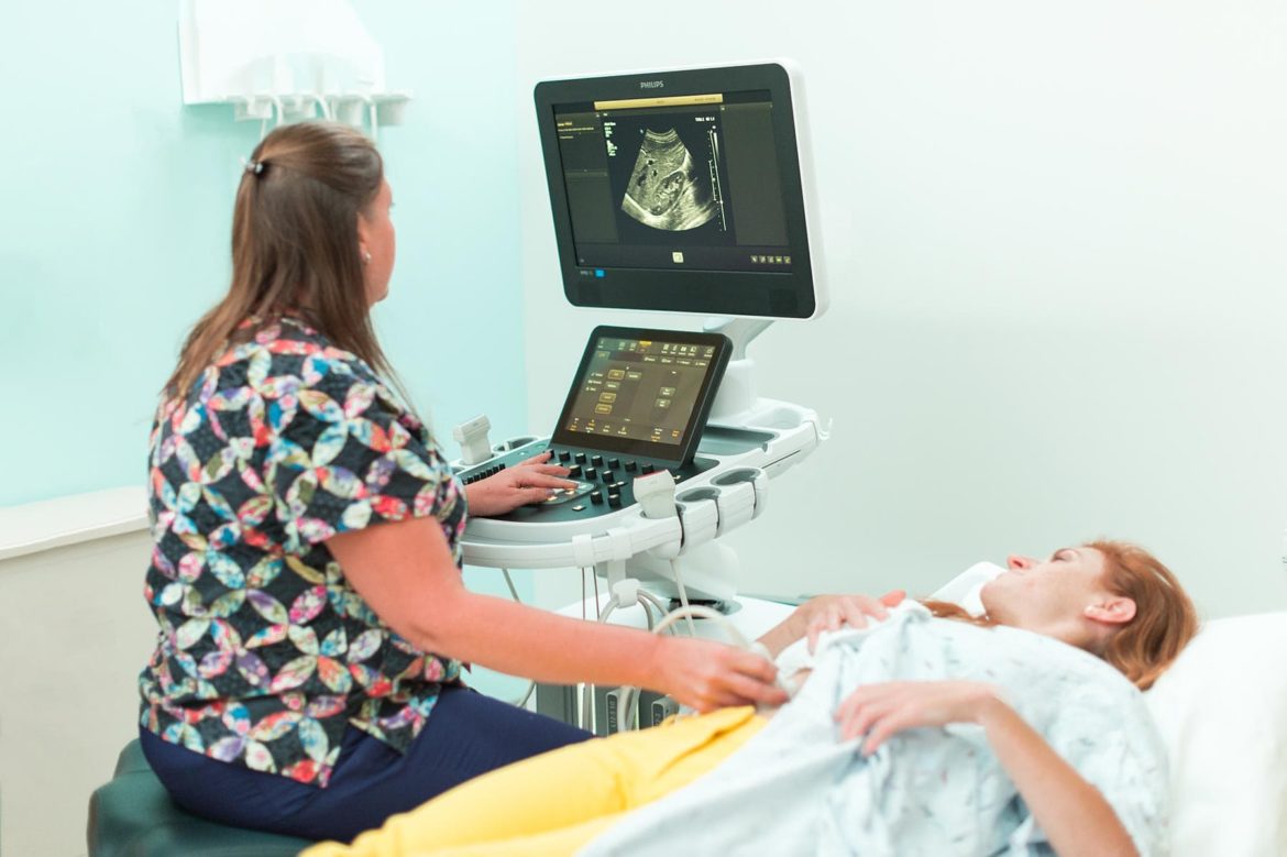 A female technologist gives a girl an ultrasound exam