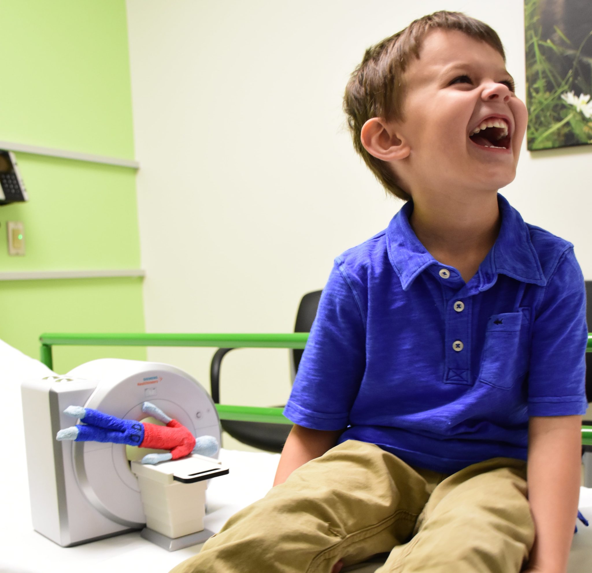 A boy laughs while sitting in a medical waiting room