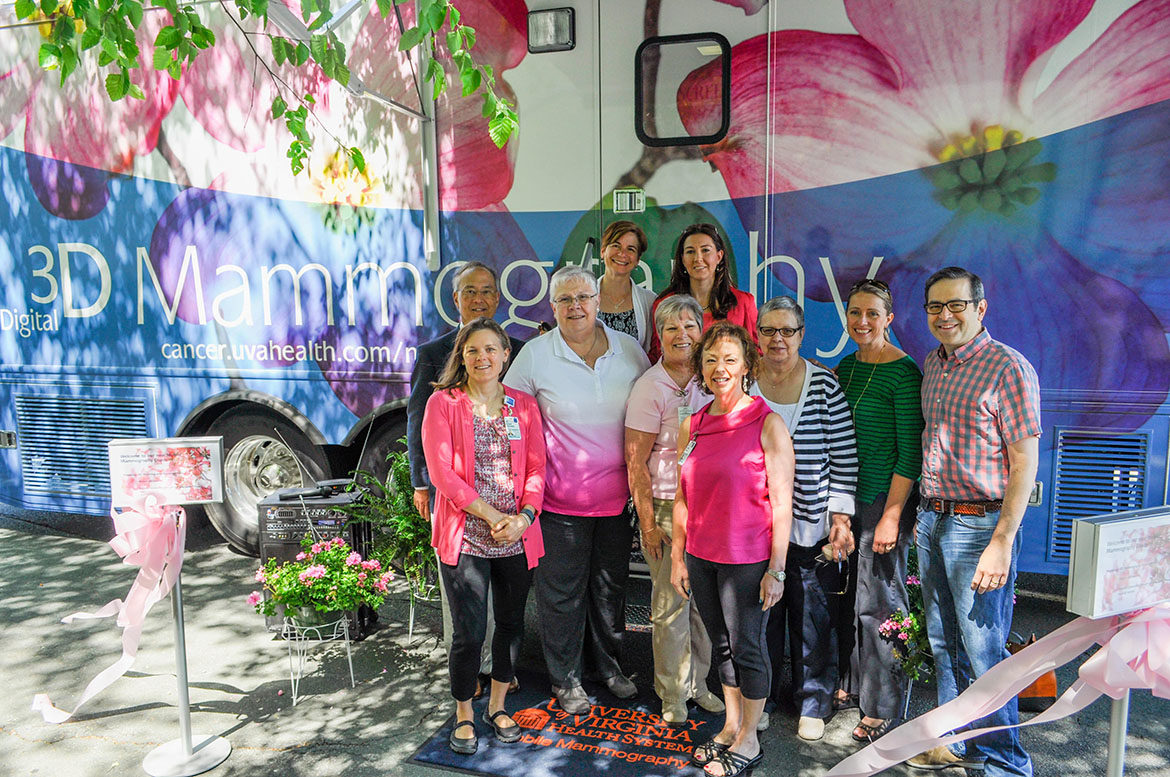 a group of radiologists, technologists, doctors, and staff stand in front of the UVA mobile mammography coach